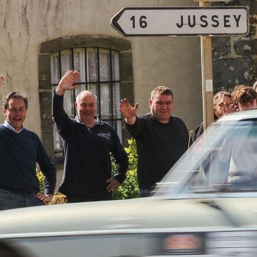 Zwaaiende toeschouwers langs de route terwijl een klassieker voorbijkomt