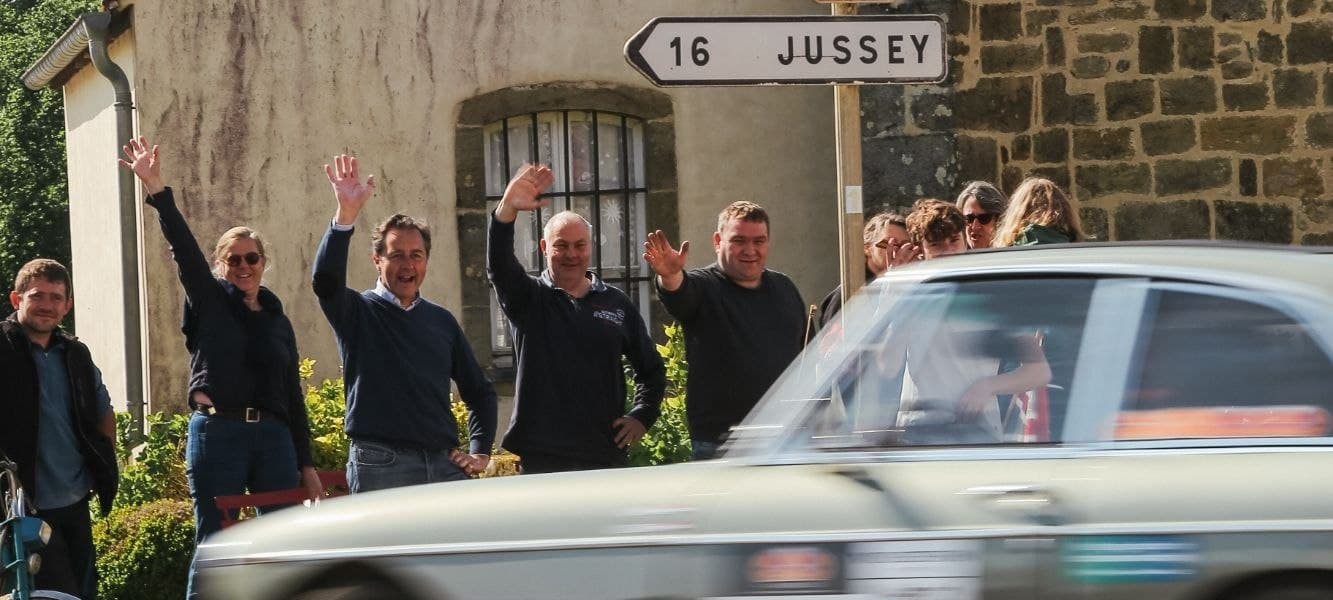 Zwaaiende toeschouwers langs de route terwijl een klassieker voorbijkomt